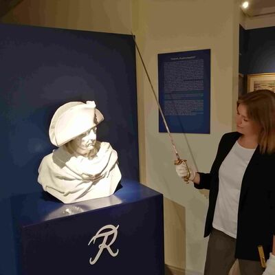 Museumsassistentin Lea Hentschel mit einem S&auml;bel neben der B&uuml;ste von Friedrich der Gro&szlig;e im ReMO - Regionalmuseum Oberhavel.